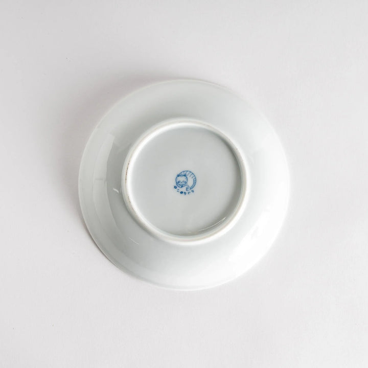 A cereal bowl with a cheerful blue and white cat, playfully kicking its leg up.