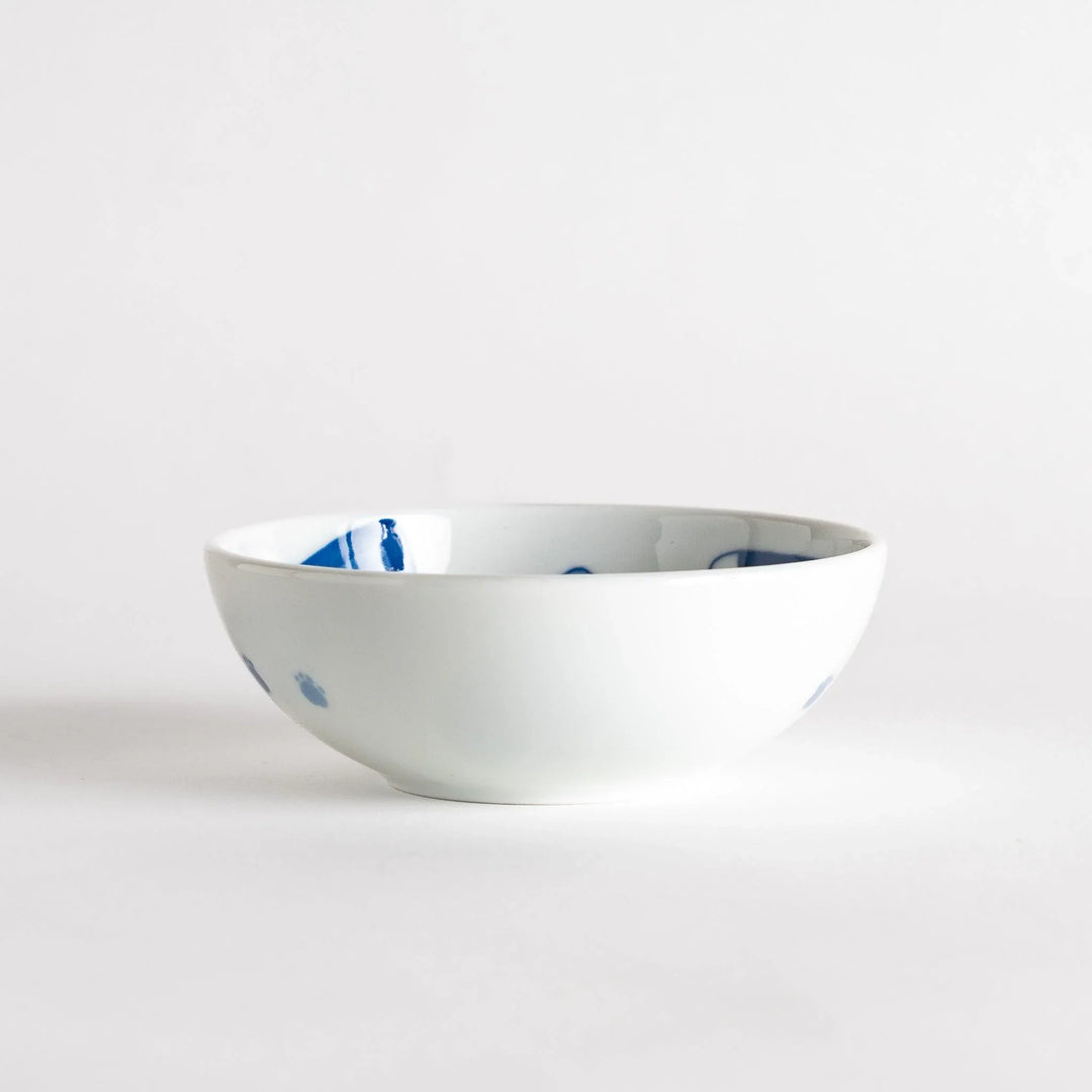 A dessert bowl featuring a playful blue and white cat with a relaxed expression.