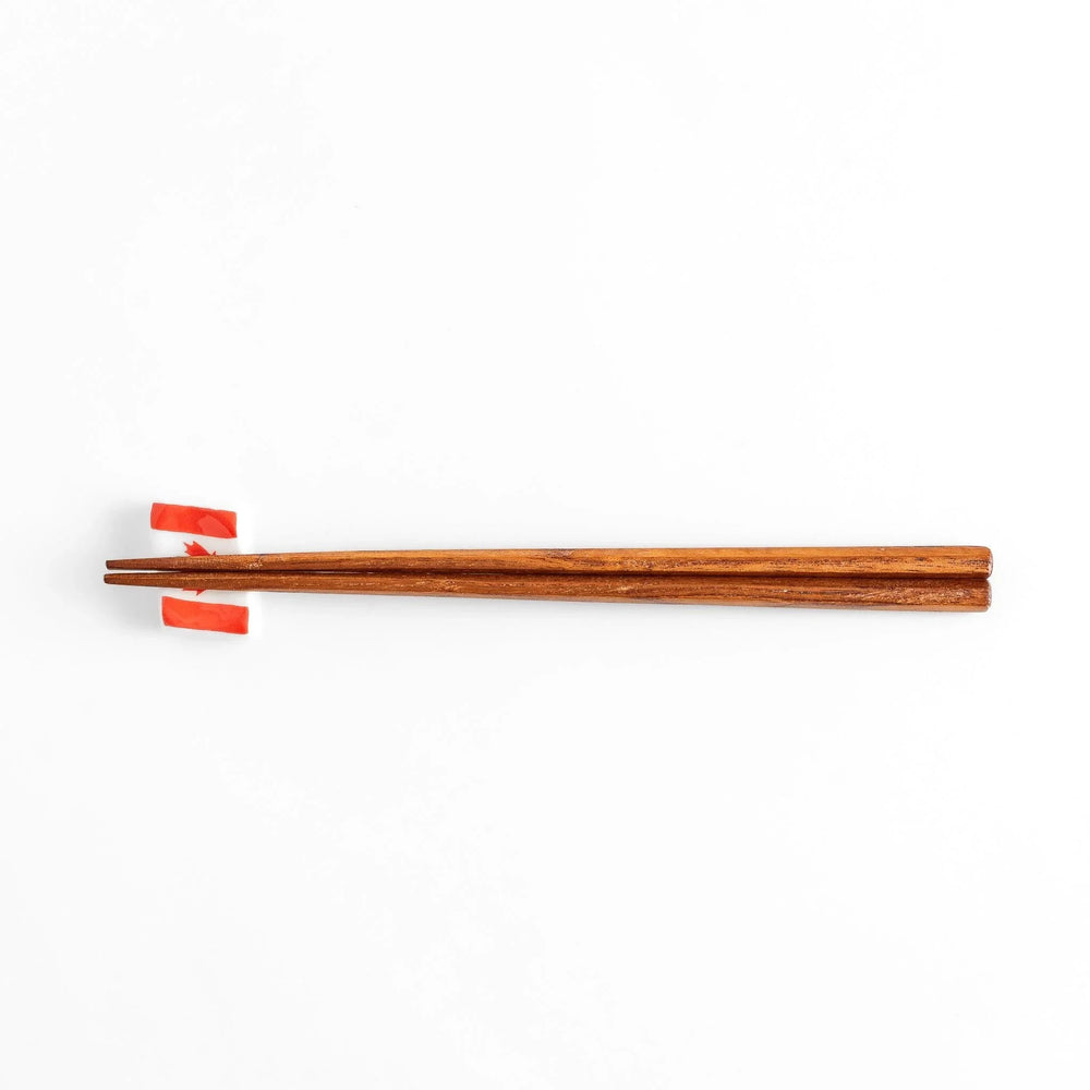 Chopstick rest shaped like the Canadian flag, featuring a red maple leaf in the center, with red borders on each side.