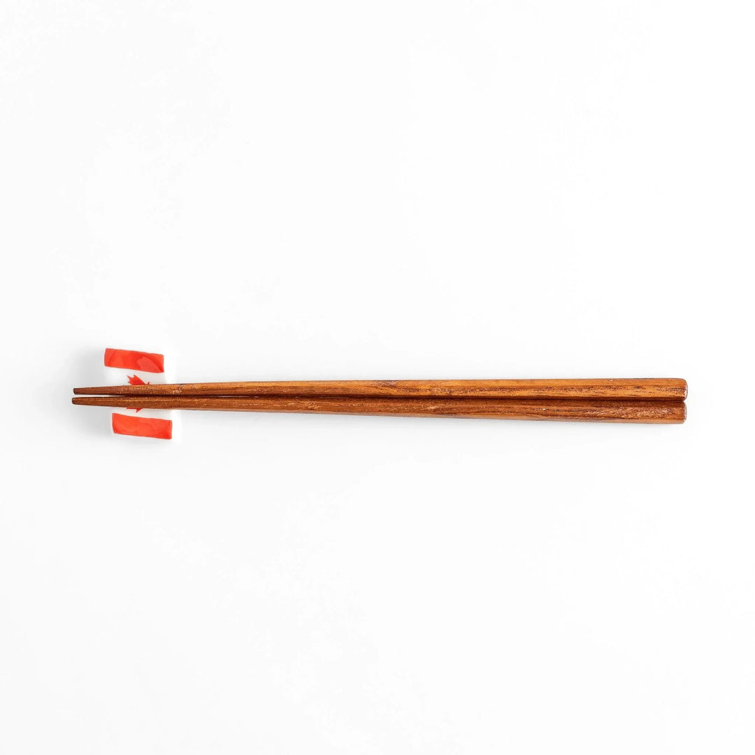 Chopstick rest shaped like the Canadian flag, featuring a red maple leaf in the center, with red borders on each side.