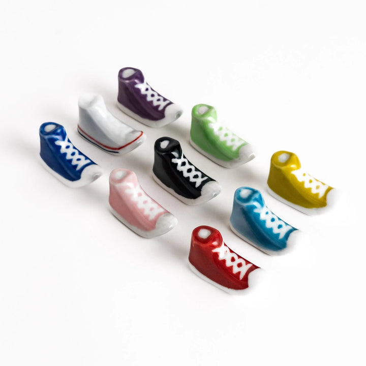 Colorful sneaker shaped chopstick rests in rows featuring playful high top designs in assorted colors.