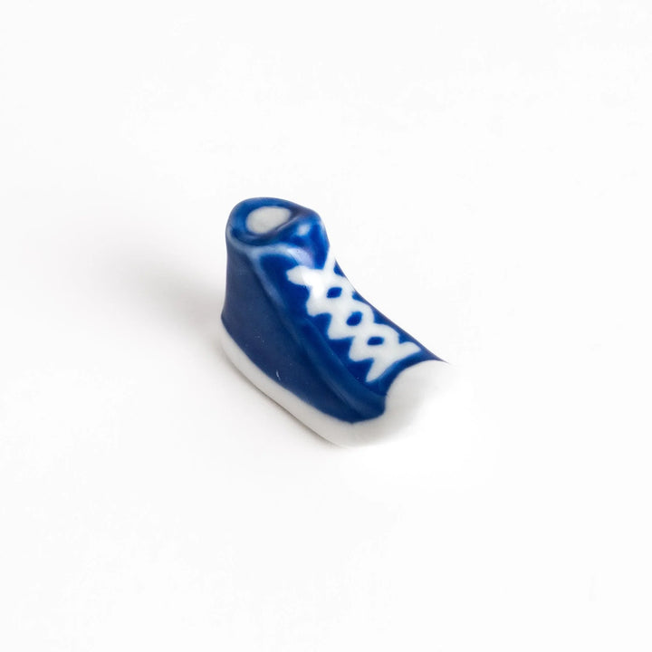 Canvas sneaker shaped ceramic chopstick rest featuring detailed laces and sole design adding playful touch to dining.