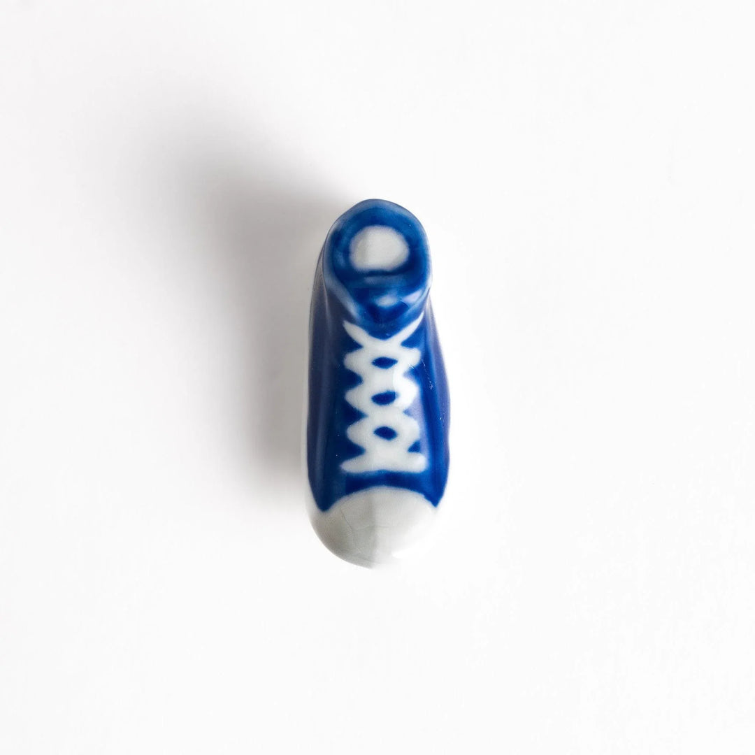 Canvas sneaker shaped ceramic chopstick rest featuring detailed laces and sole design adding playful touch to dining.