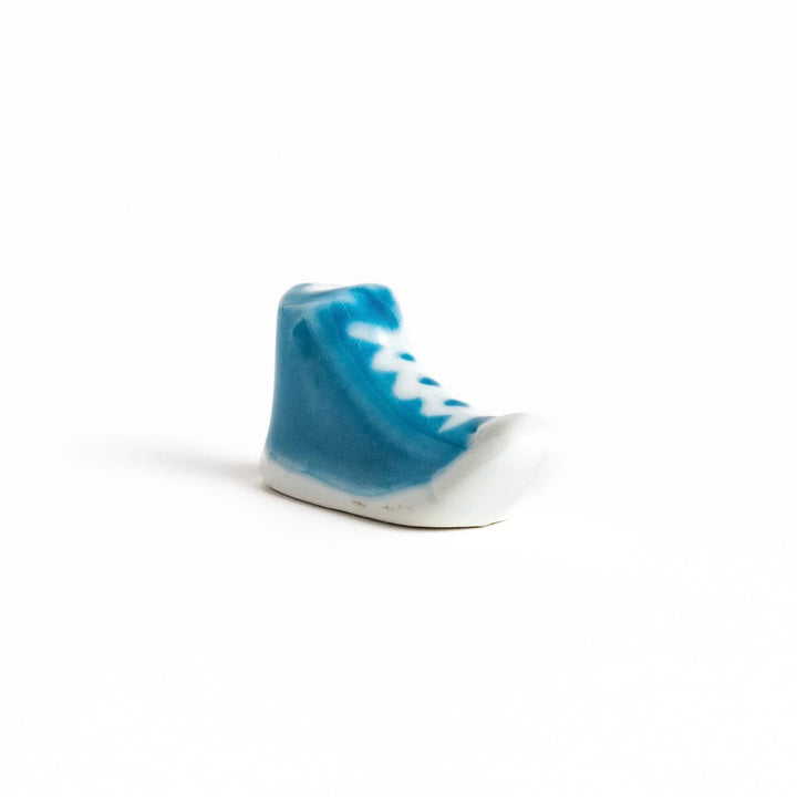 Canvas sneaker shaped ceramic chopstick rest featuring detailed laces and sole design adding playful touch to dining.