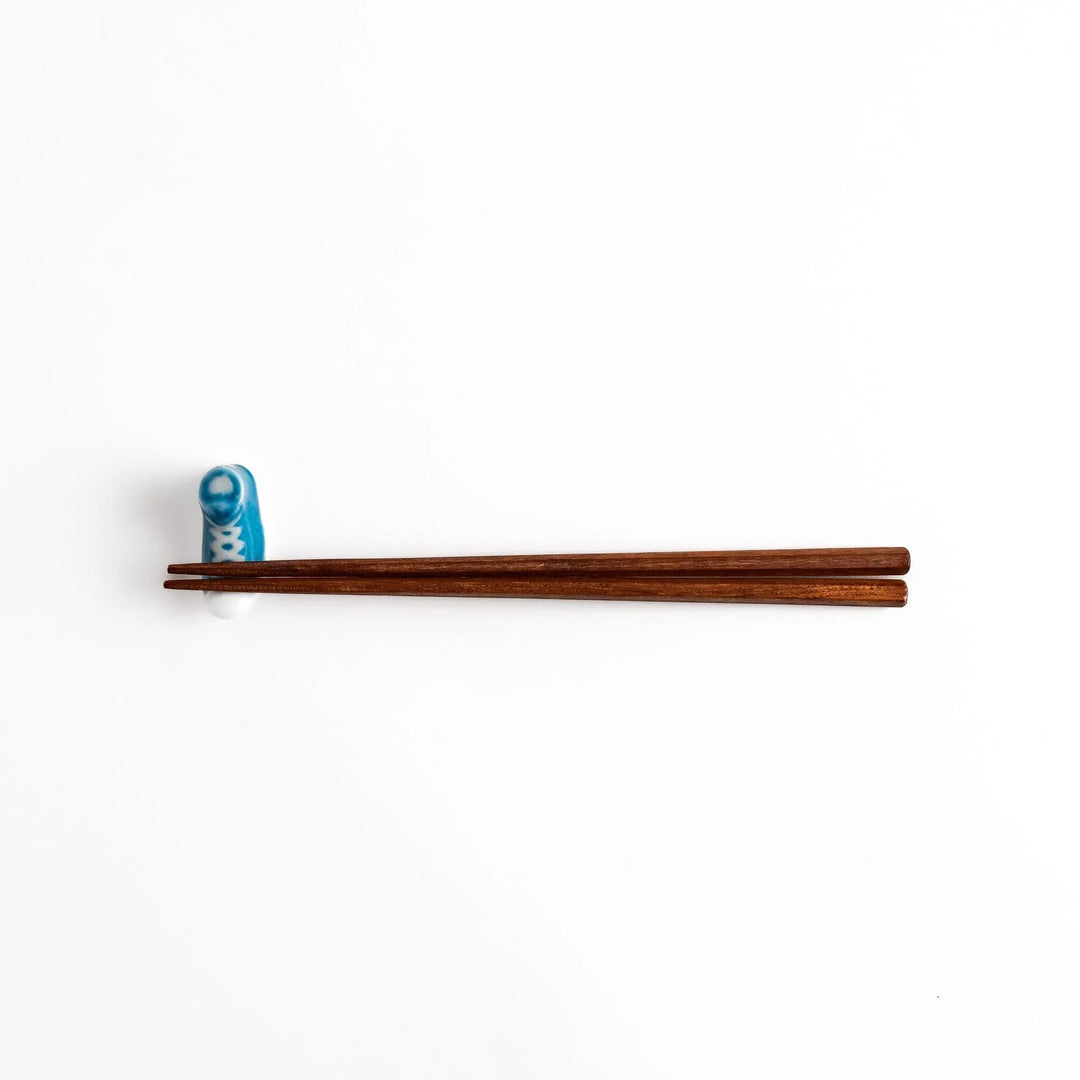 Canvas sneaker shaped ceramic chopstick rest featuring detailed laces and sole design adding playful touch to dining.