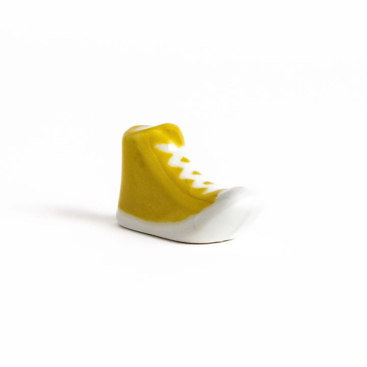 Canvas sneaker shaped ceramic chopstick rest featuring detailed laces and sole design adding playful touch to dining.