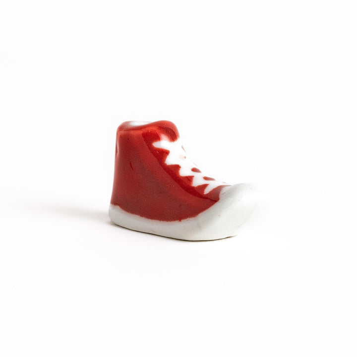 Canvas sneaker shaped ceramic chopstick rest featuring detailed laces and sole design adding playful touch to dining.