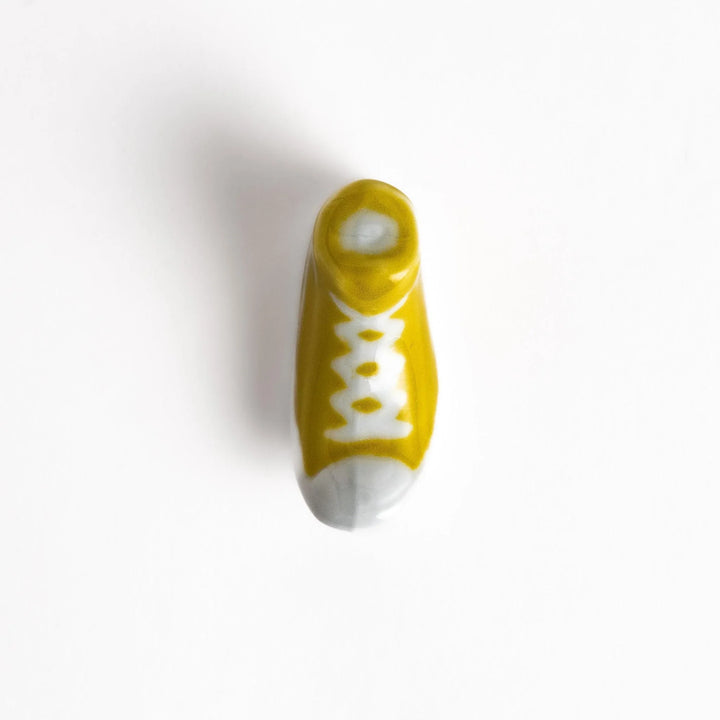Canvas sneaker shaped ceramic chopstick rest featuring detailed laces and sole design adding playful touch to dining.