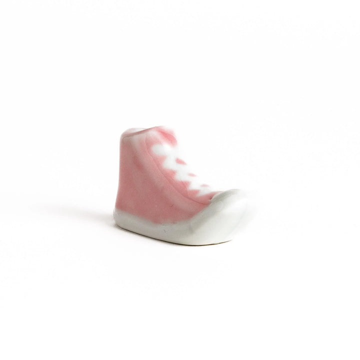 Canvas sneaker shaped ceramic chopstick rest featuring detailed laces and sole design adding playful touch to dining.