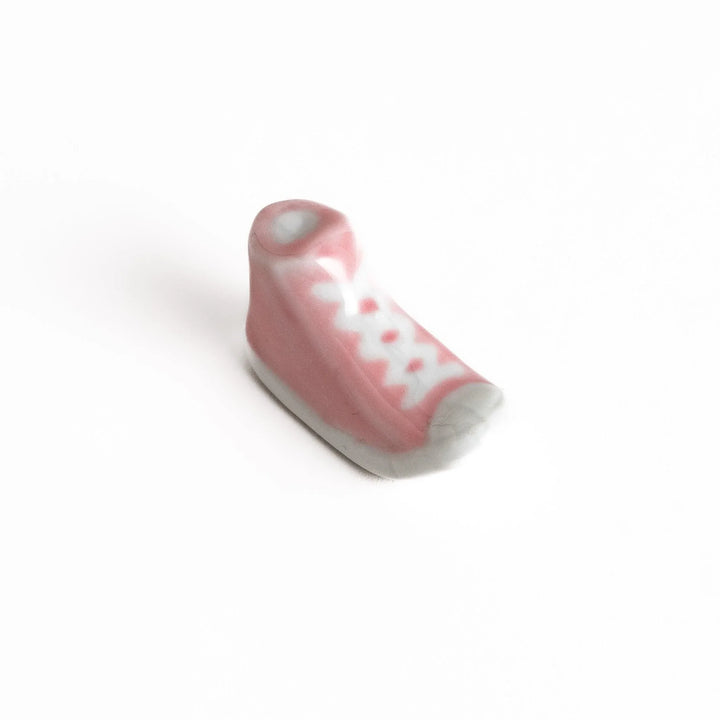 Canvas sneaker shaped ceramic chopstick rest featuring detailed laces and sole design adding playful touch to dining.