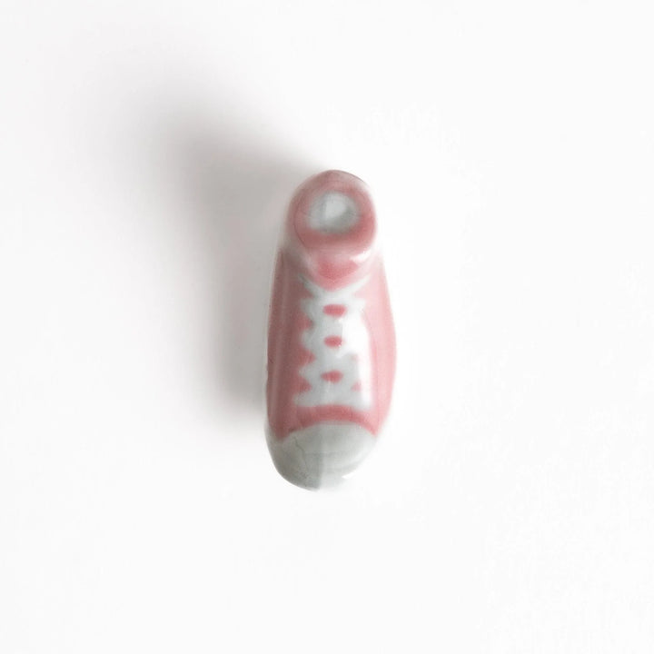 Canvas sneaker shaped ceramic chopstick rest featuring detailed laces and sole design adding playful touch to dining.