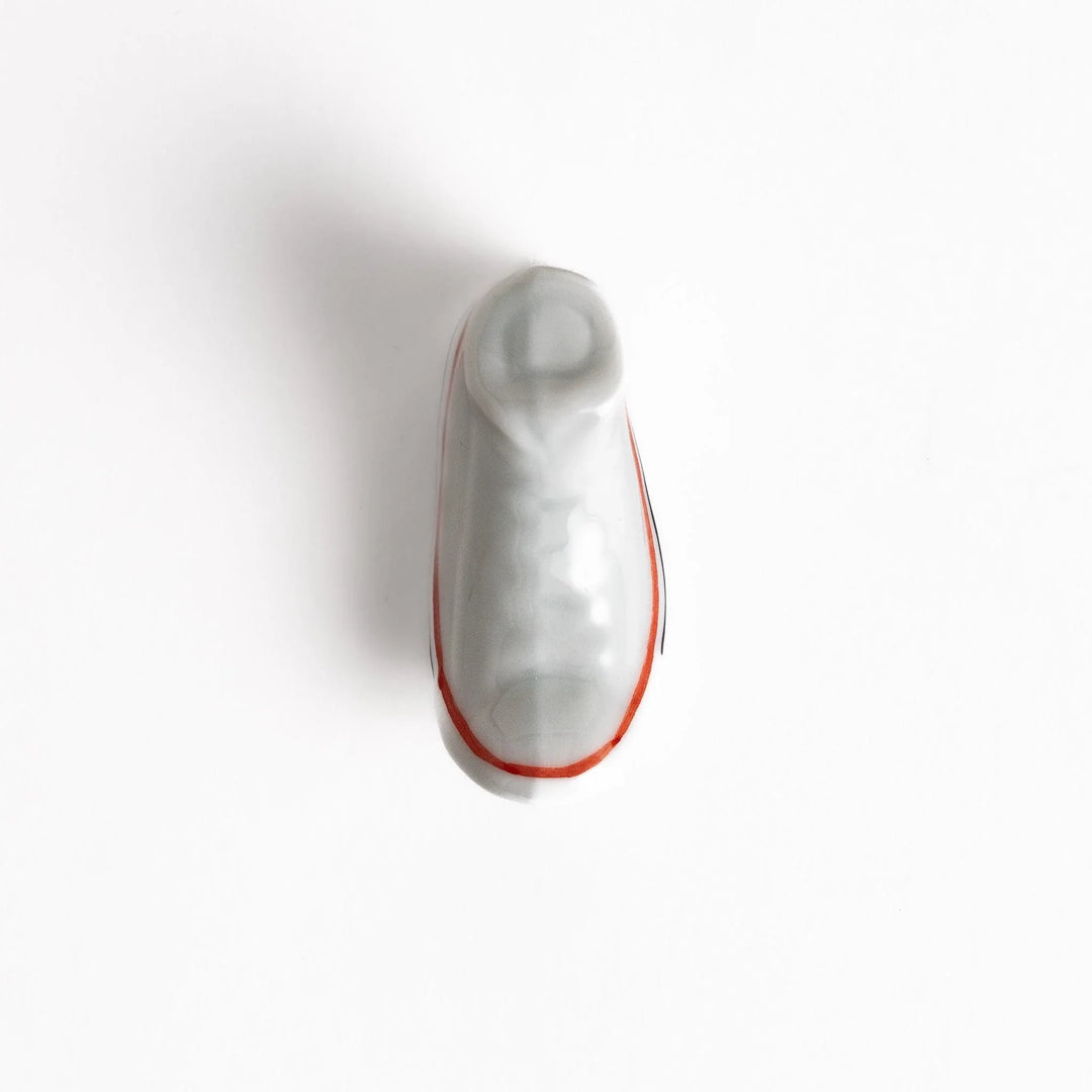 Canvas sneaker shaped ceramic chopstick rest featuring detailed laces and sole design adding playful touch to dining.