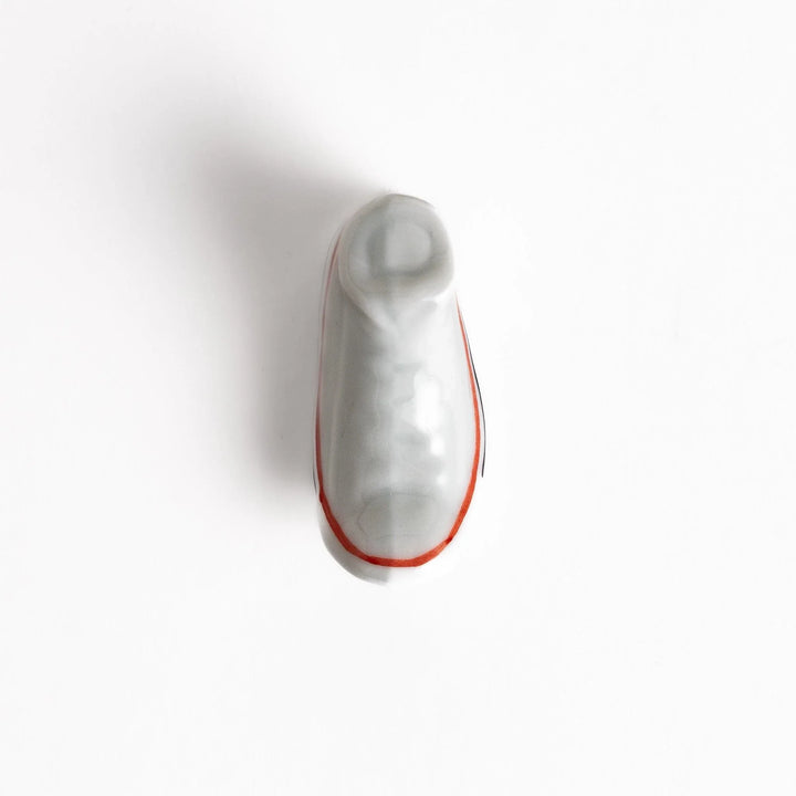 Canvas sneaker shaped ceramic chopstick rest featuring detailed laces and sole design adding playful touch to dining.
