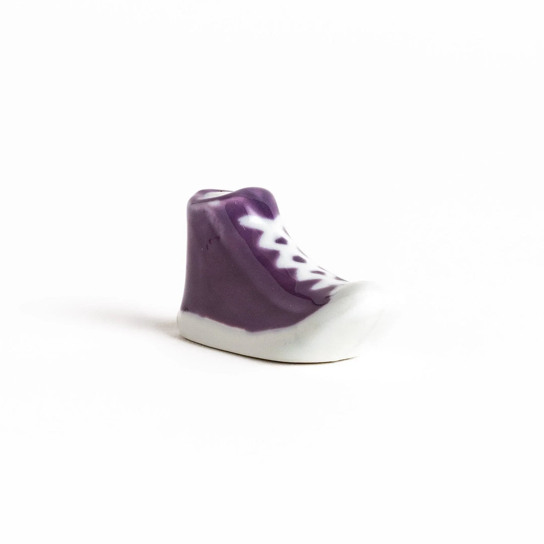 Canvas sneaker shaped ceramic chopstick rest featuring detailed laces and sole design adding playful touch to dining.