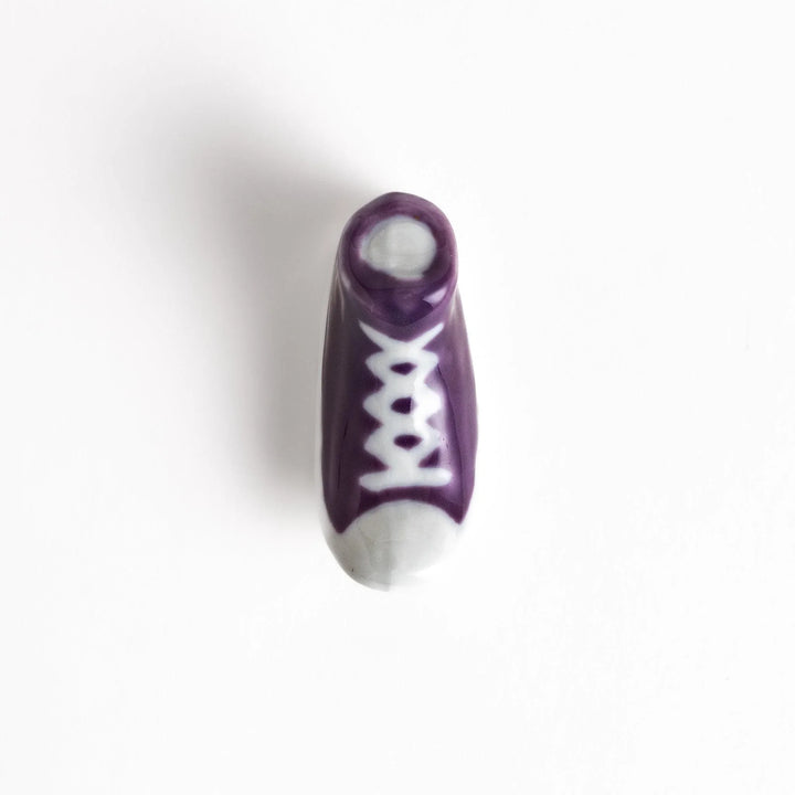 Canvas sneaker shaped ceramic chopstick rest featuring detailed laces and sole design adding playful touch to dining.