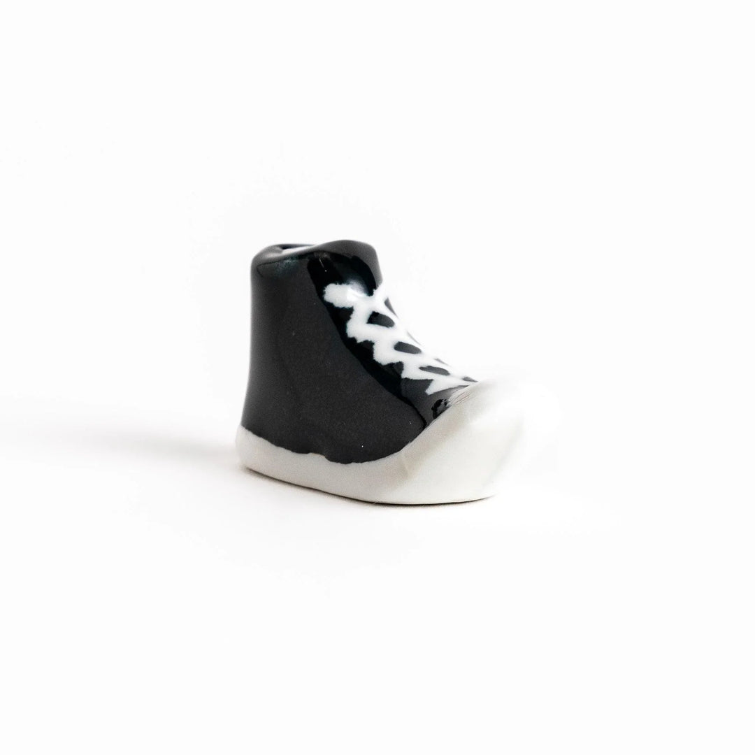 Canvas sneaker shaped ceramic chopstick rest featuring detailed laces and sole design adding playful touch to dining.