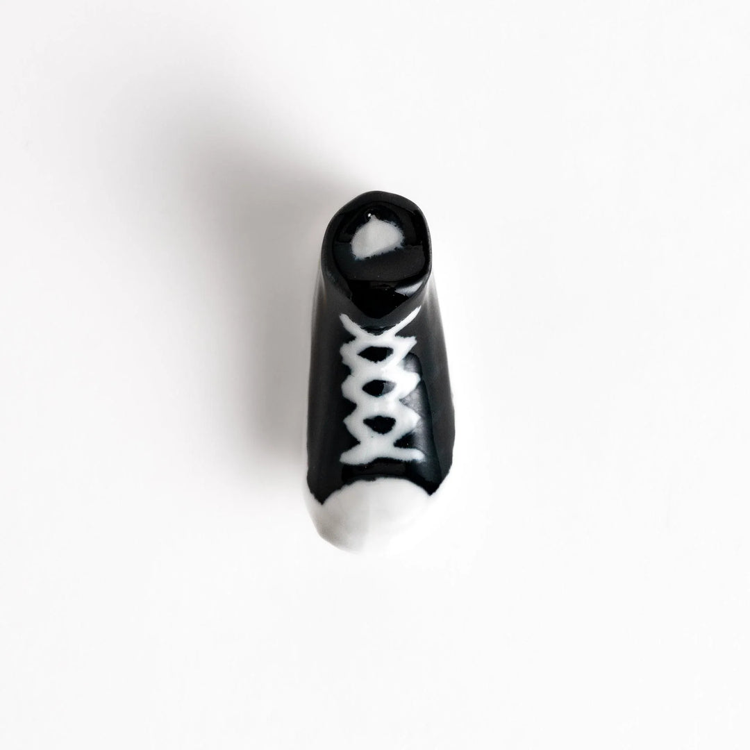 Canvas sneaker shaped ceramic chopstick rest featuring detailed laces and sole design adding playful touch to dining.