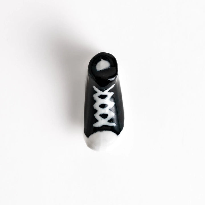 Canvas sneaker shaped ceramic chopstick rest featuring detailed laces and sole design adding playful touch to dining.