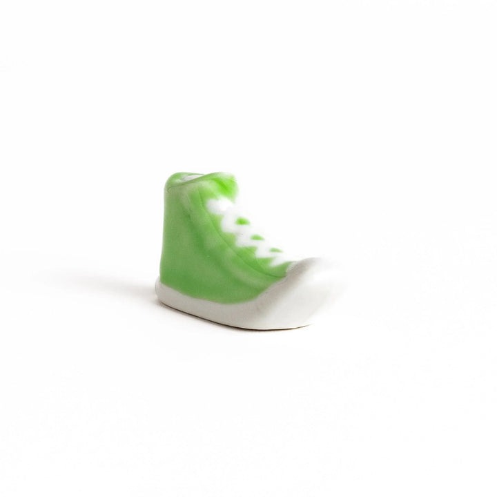 Canvas sneaker shaped ceramic chopstick rest featuring detailed laces and sole design adding playful touch to dining.