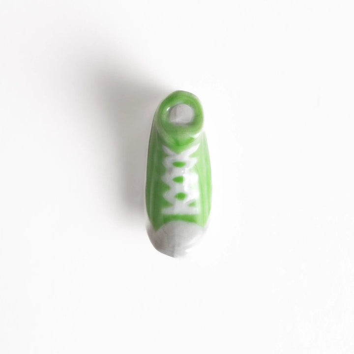 Canvas sneaker shaped ceramic chopstick rest featuring detailed laces and sole design adding playful touch to dining.