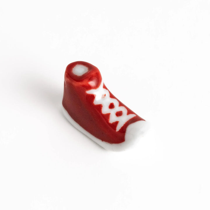 Canvas sneaker shaped ceramic chopstick rest featuring detailed laces and sole design adding playful touch to dining.