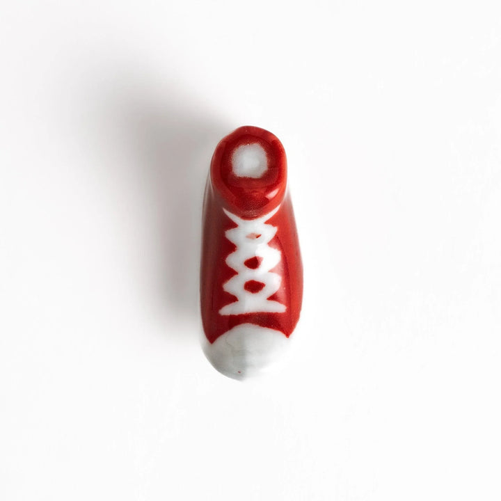 Canvas sneaker shaped ceramic chopstick rest featuring detailed laces and sole design adding playful touch to dining.