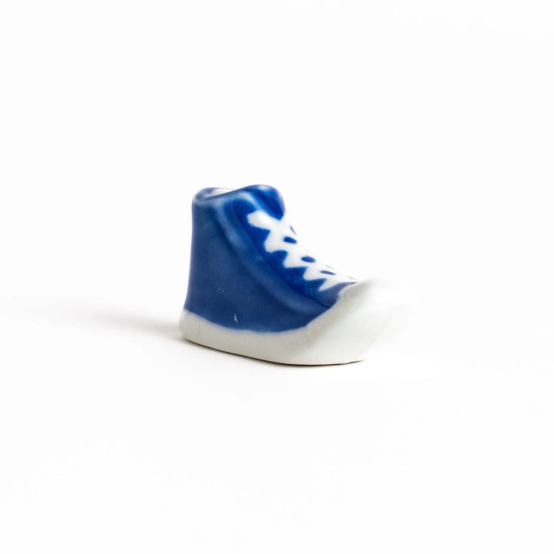 Canvas sneaker shaped ceramic chopstick rest featuring detailed laces and sole design adding playful touch to dining.