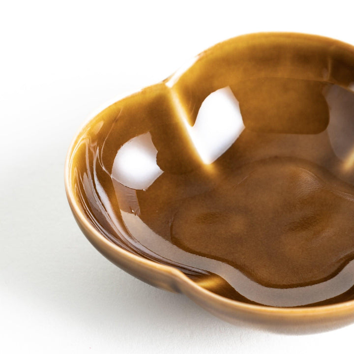 A small, brown ceramic dish shaped like a quince.