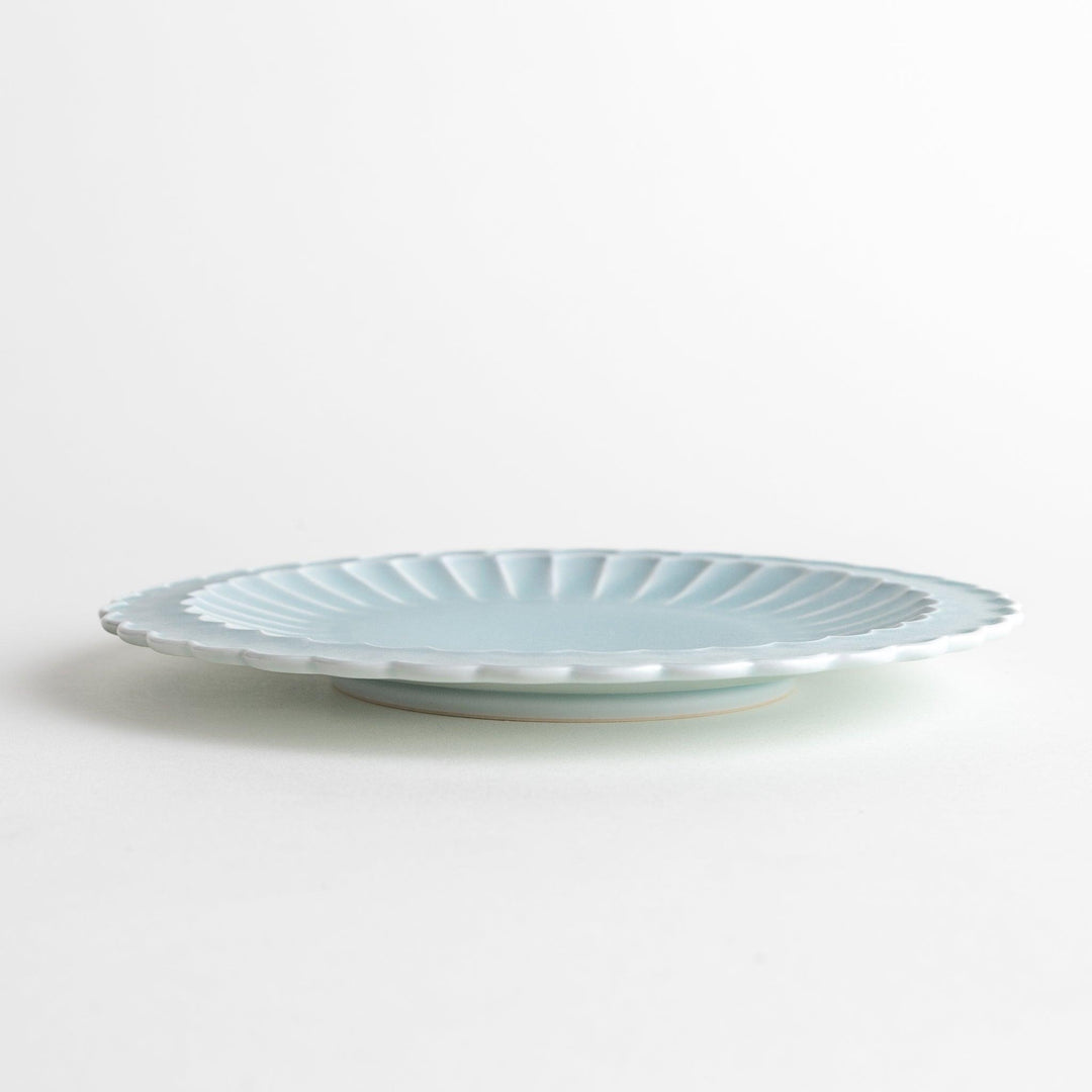 Fluted ceramic salad plate in matte black and light blue.