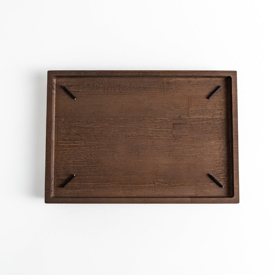 Dark wooden board with notched corners, showcasing a natural grain pattern.