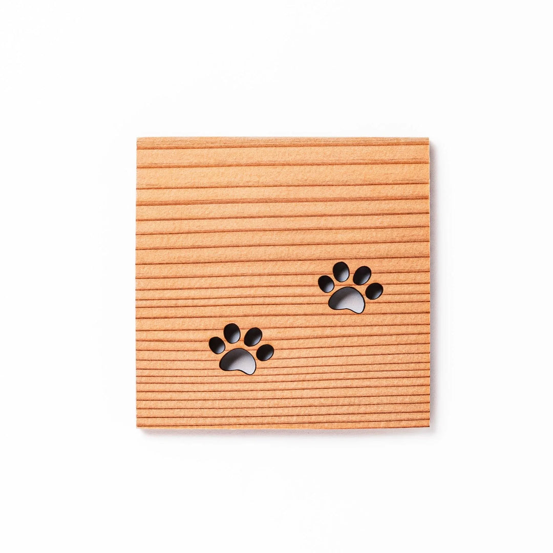 Square cedar mini coaster with two laser-cut cat paw prints, natural warm wood grain, perfect for small cups or glasses.