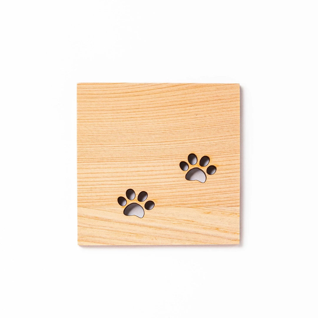 Square hinoki wood mini coaster with two cat paw cutouts, showcasing light grain and protecting surfaces.