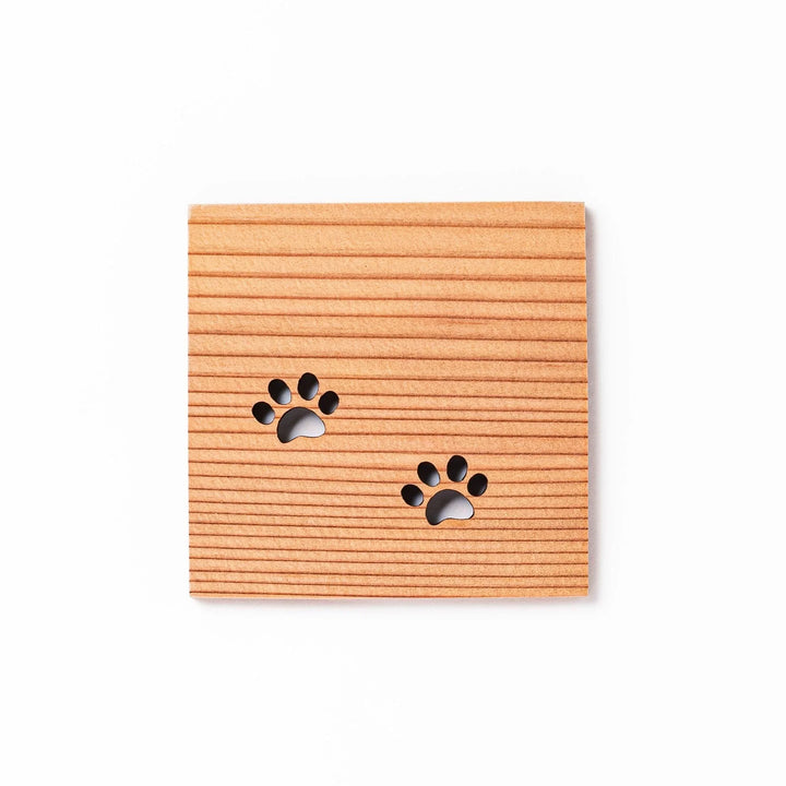 Square cedar mini coaster with two laser-cut cat paw prints, natural warm wood grain, perfect for small cups or glasses.