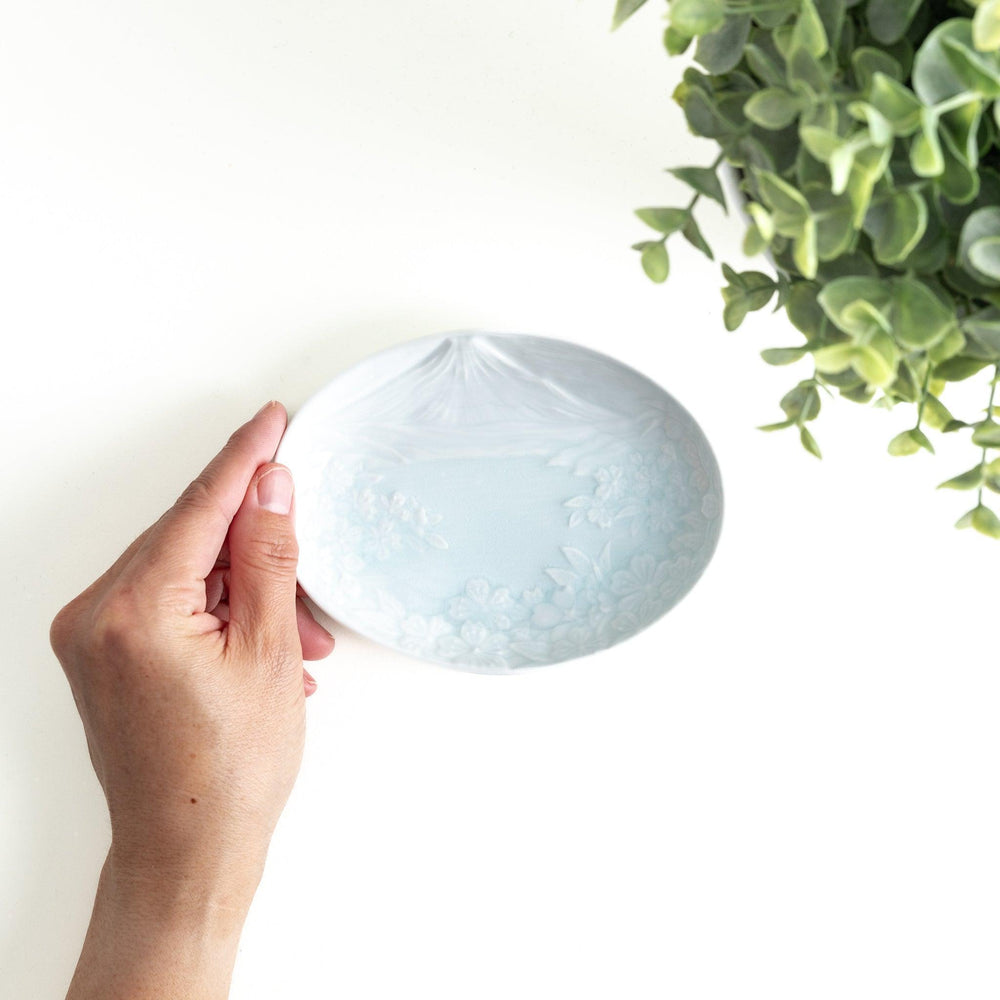 Round celadon dessert plate with raised Mount Fuji pattern and glossy finish symbolizing Japanese nature.