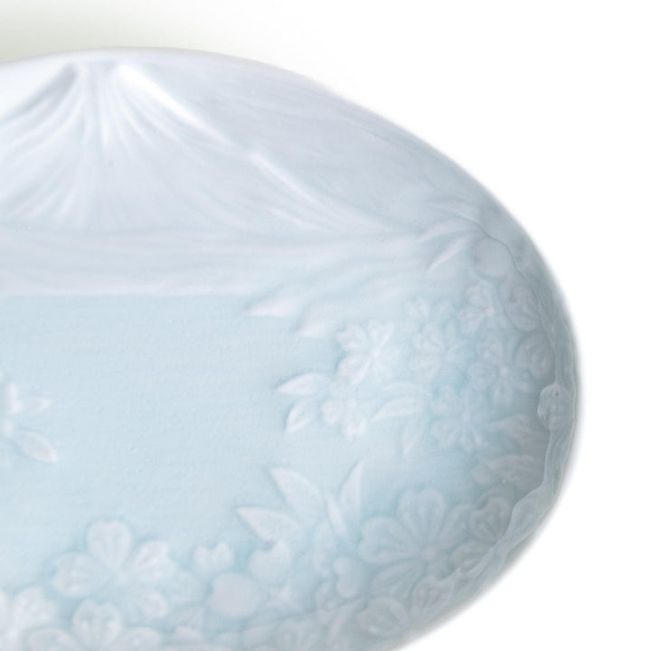 Round celadon dessert plate with raised Mount Fuji pattern and glossy finish symbolizing Japanese nature.