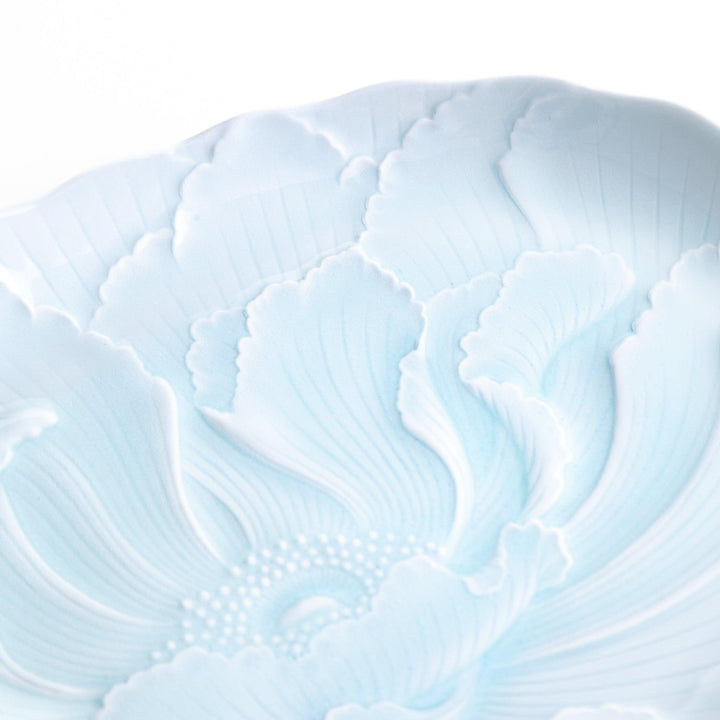 A large oval serving plate with a subtle raised floral design in celadon, featuring a delicate pattern of petals.