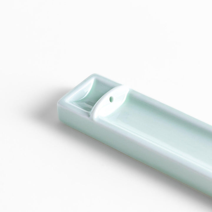 Celadon ceramic incense holder with built-in slot and rectangular shape elegantly catching falling incense ash.