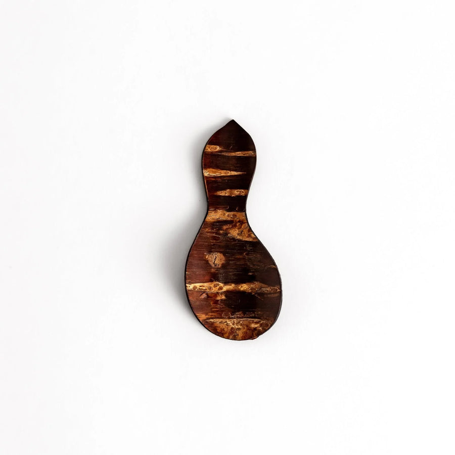 Cherry bark tea scoop with curved design and natural grain perfect for measuring loose leaf tea with artistry.