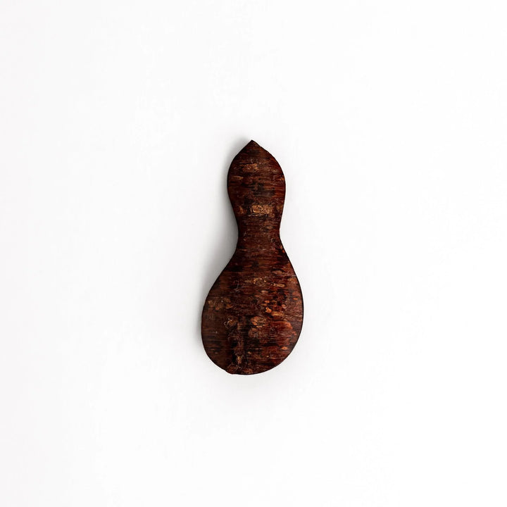 Cherry bark tea scoop with curved design and natural grain perfect for measuring loose leaf tea with artistry.