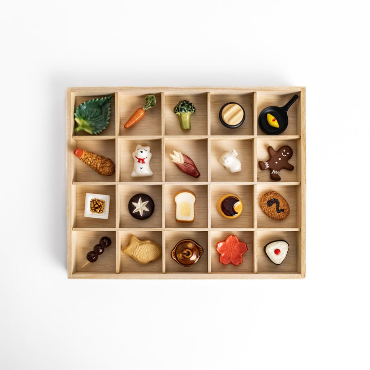 A wooden organizer with 20 charming chopstick rests in various shapes, including vegetables, animals, and food items.