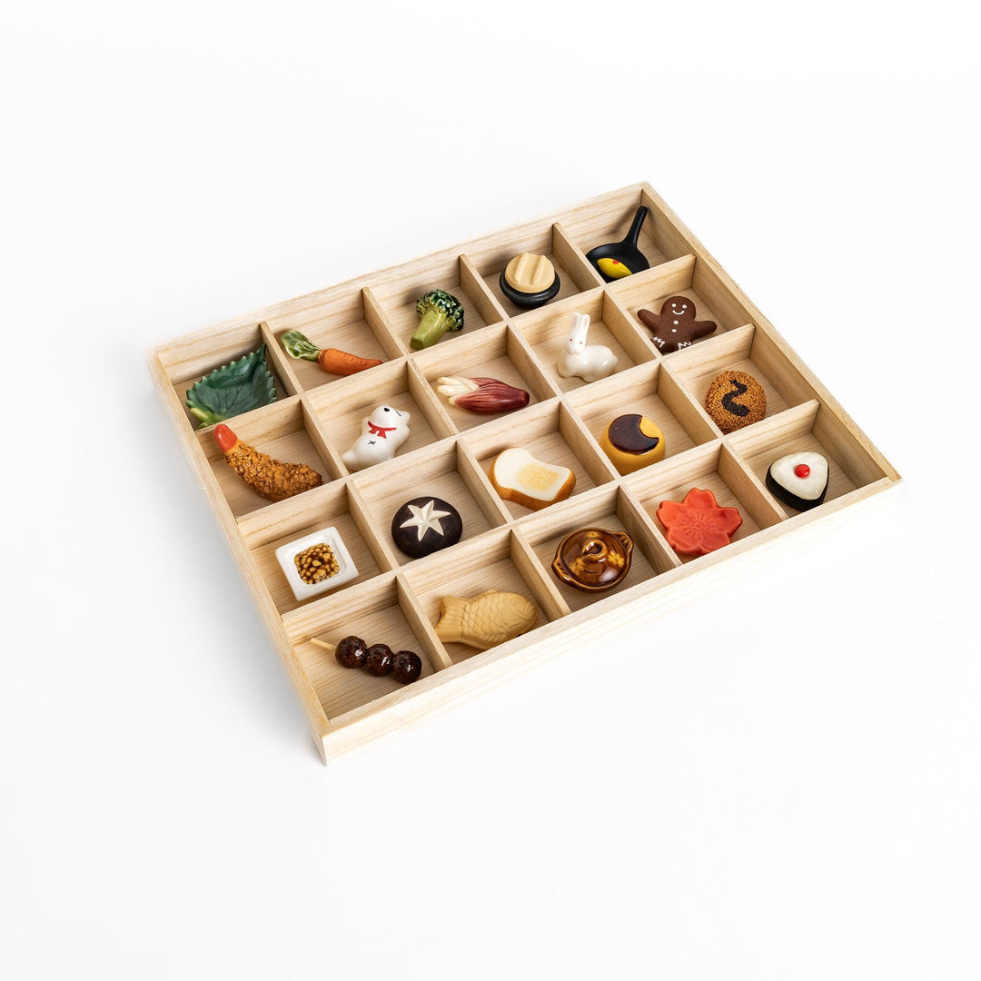A wooden organizer with 20 charming chopstick rests in various shapes, including vegetables, animals, and food items.