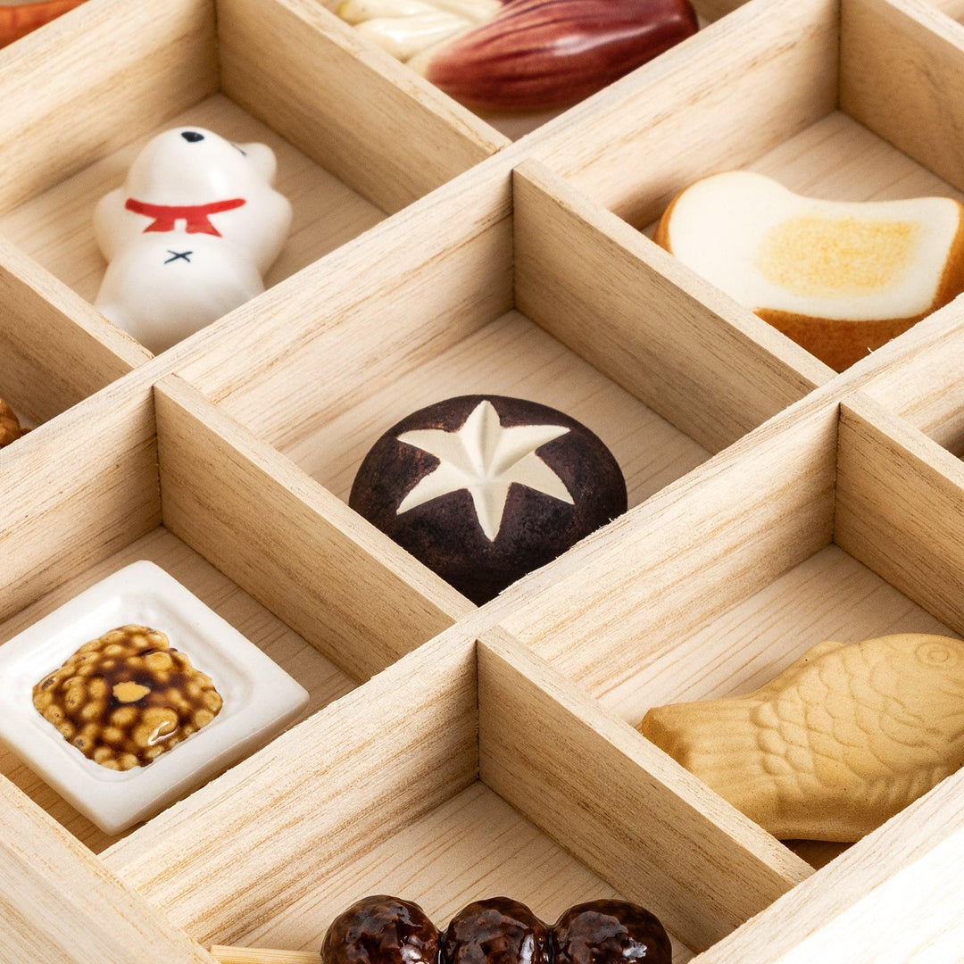 A wooden organizer with 20 charming chopstick rests in various shapes, including vegetables, animals, and food items.