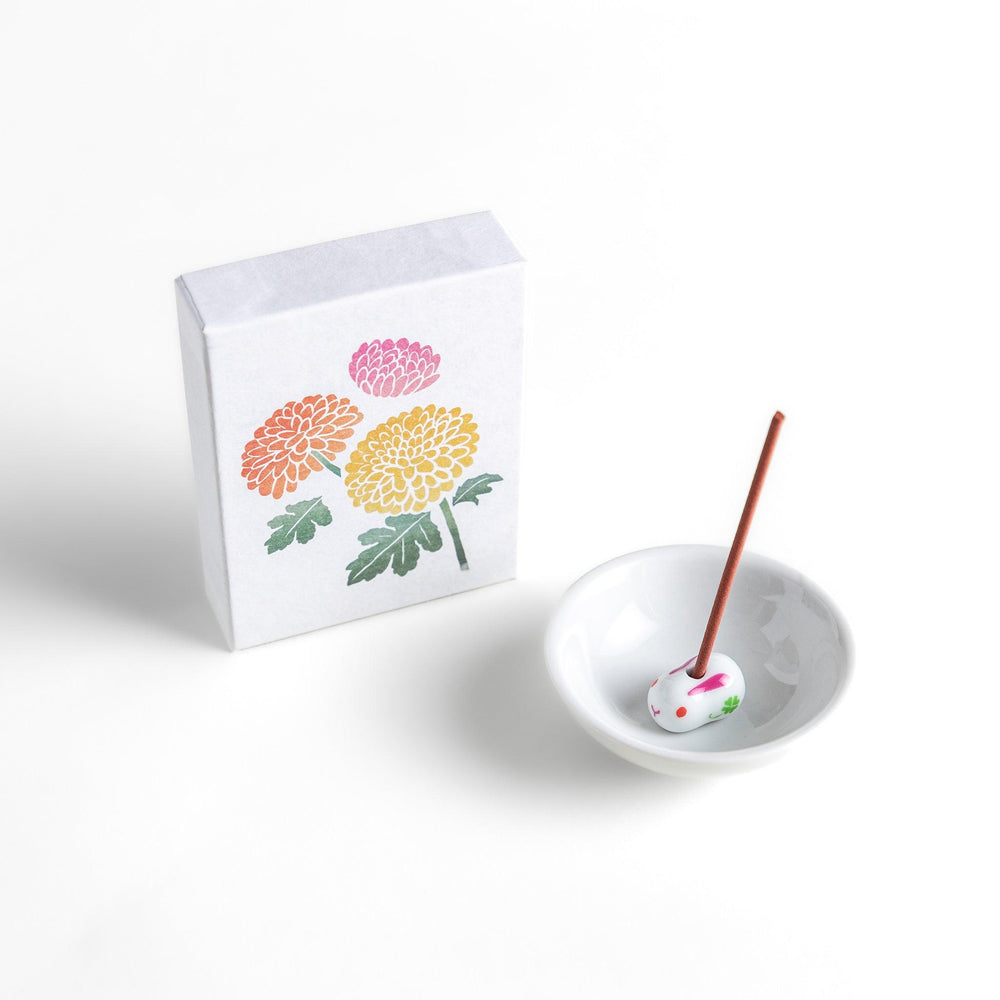 Incense with brown sticks in a chrysanthemum box, offering a refined floral aroma for a calm setting.