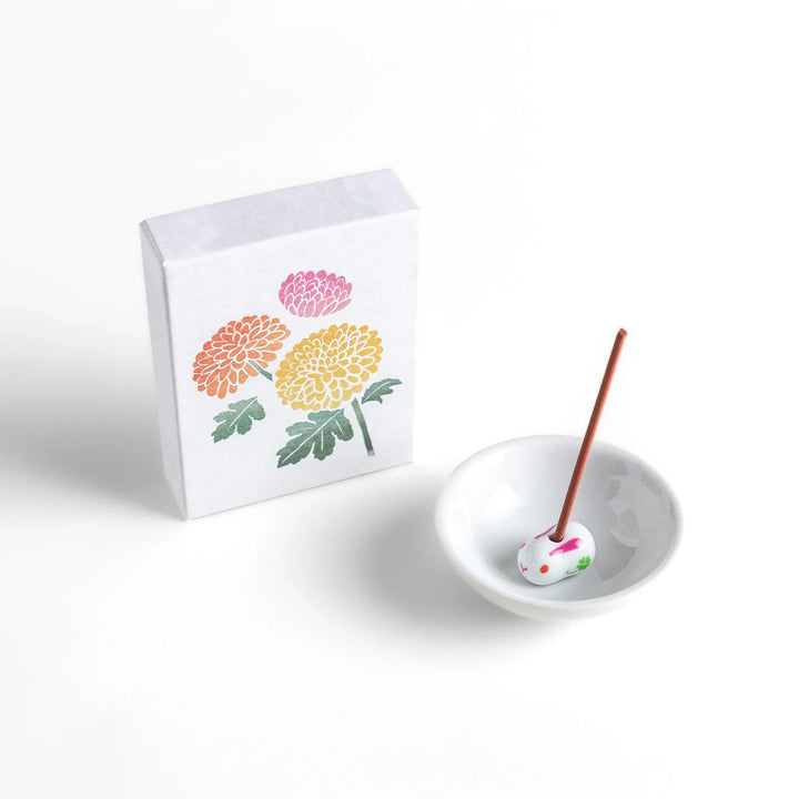 Incense with brown sticks in a chrysanthemum box, offering a refined floral aroma for a calm setting.