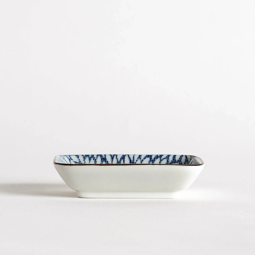 A small rectangular dish featuring a blue herringbone pattern on a white background.