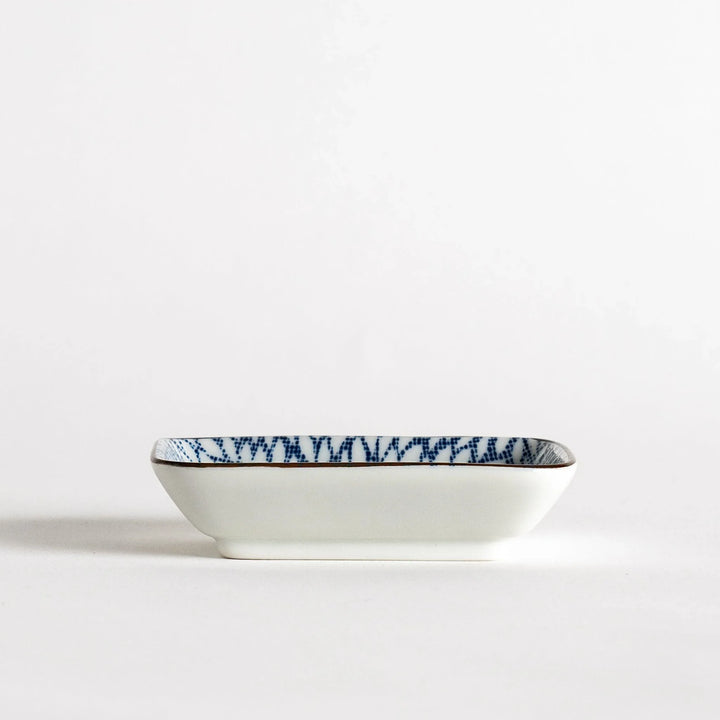 A small rectangular dish featuring a blue herringbone pattern on a white background.