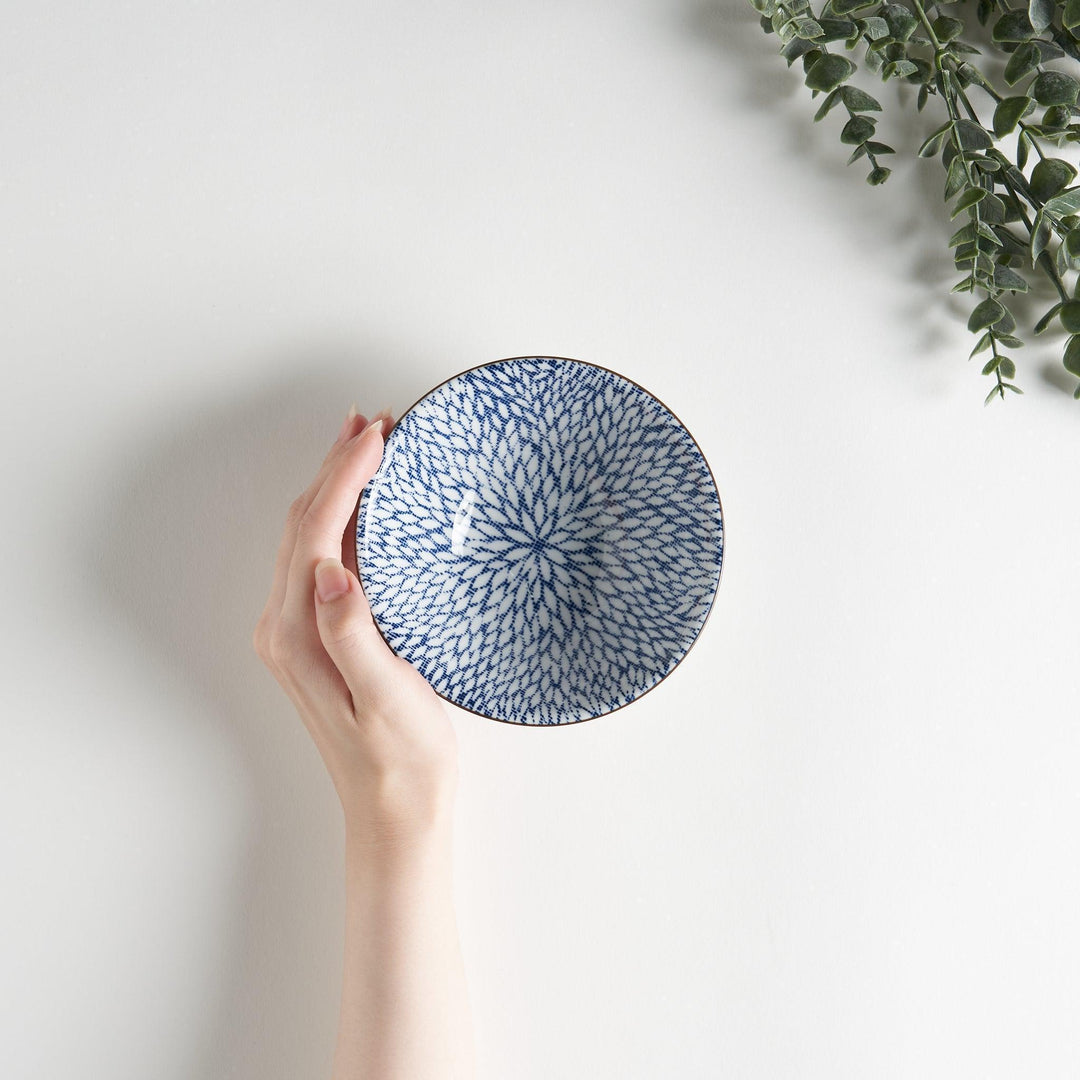 A small fluted bowl with a blue herringbone pattern on a white background.