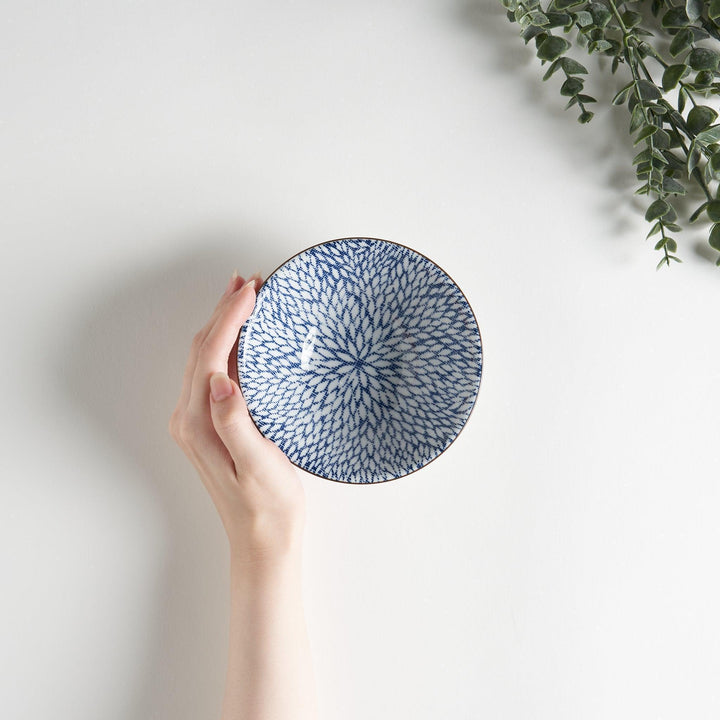 A small fluted bowl with a blue herringbone pattern on a white background.