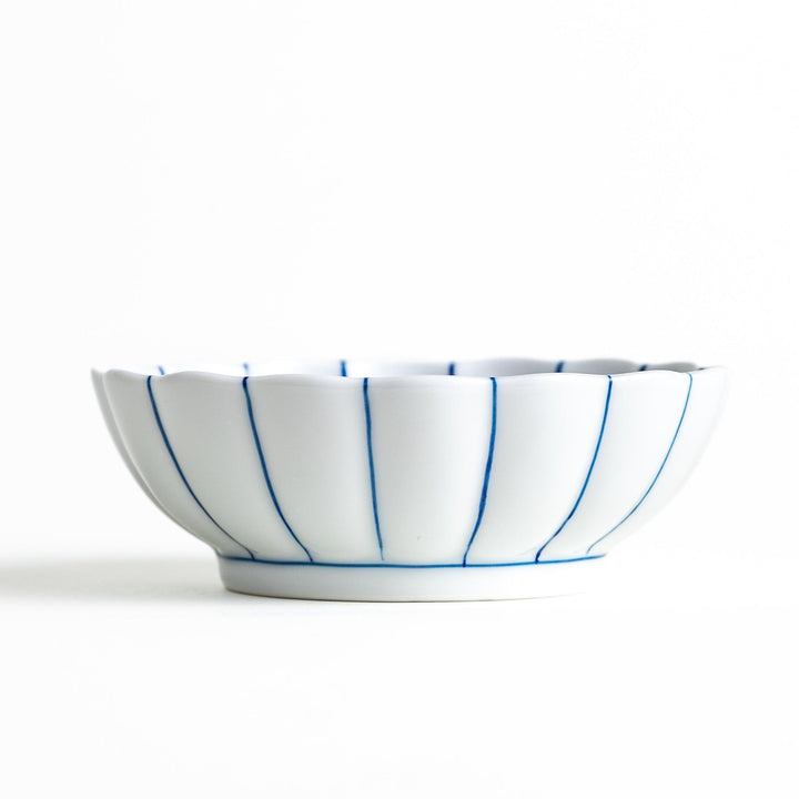 A small green dessert bowl with a scalloped edge and a blue and white wave pattern in the center.