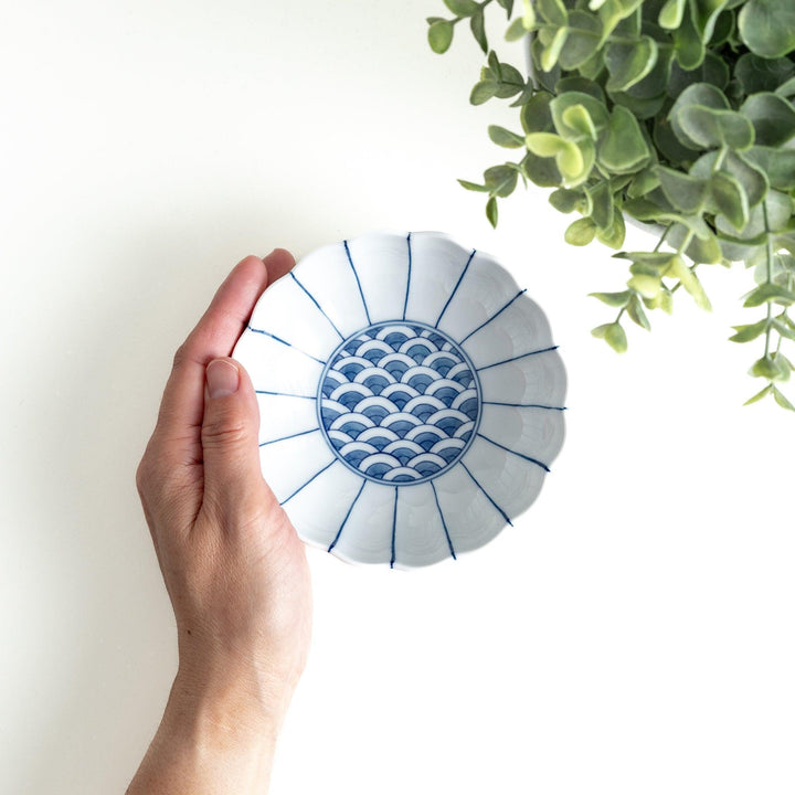 A small green dessert bowl with a scalloped edge and a blue and white wave pattern in the center.